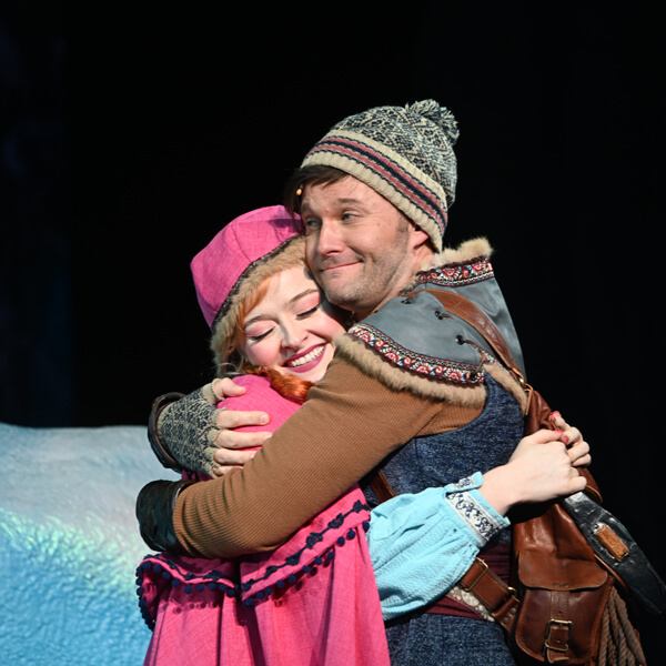 Anna and Kristoff from Frozen smile as they hug each other.