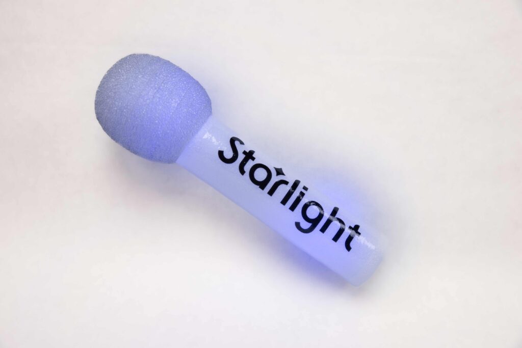 A white light foam stick on a white background. The stick looks like a microphone with the words "Starlight."