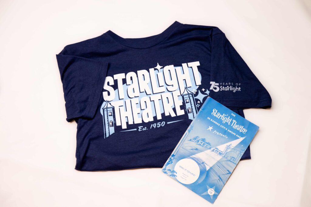 A Charlie Hustle 75 years of Starlight T-shirt is on a white background. A vintage Star Notes Pamphlet is in on top of it.
