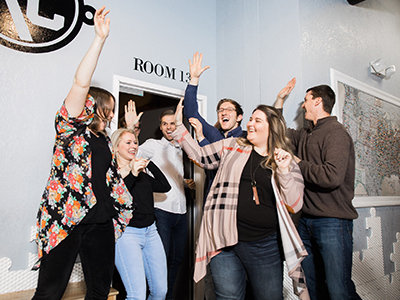 Group of adults cheer and high five each other.