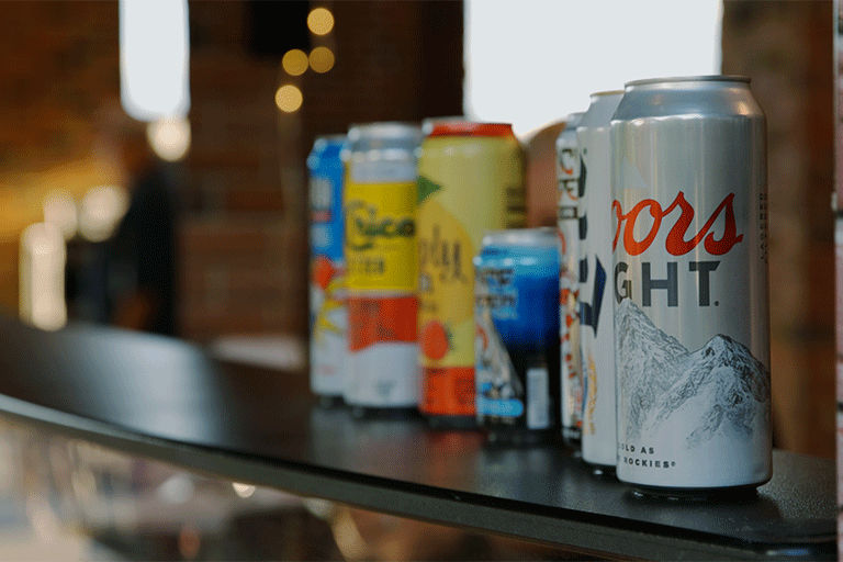 A close up of canned drinks on a bar counter.