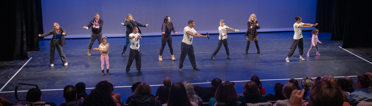 Dancers from Alvin Ailey Trio on stage teaching audience members a dance