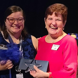 Mary Markey being handed an award by a member of Starlight staff