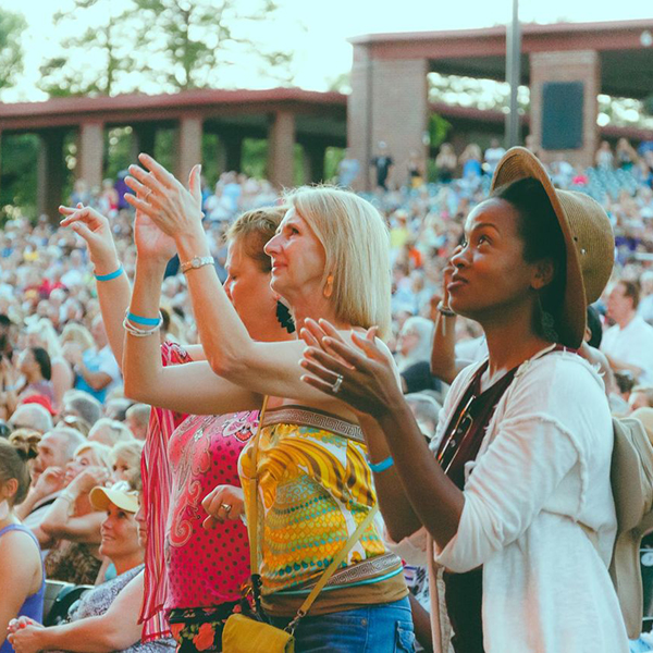 Women standing and clapping at a Starlight concert