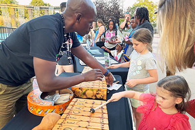 A man showing children how to use a musical instrument