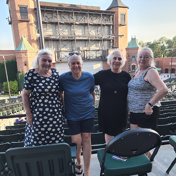 Four women posing in front of the stage house