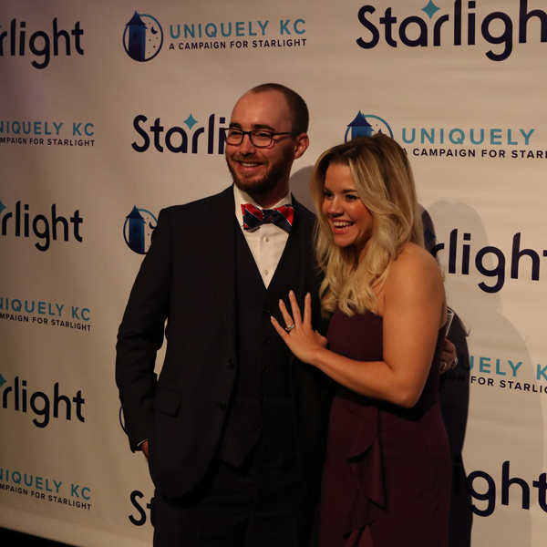 A couple posing in front of a back drop