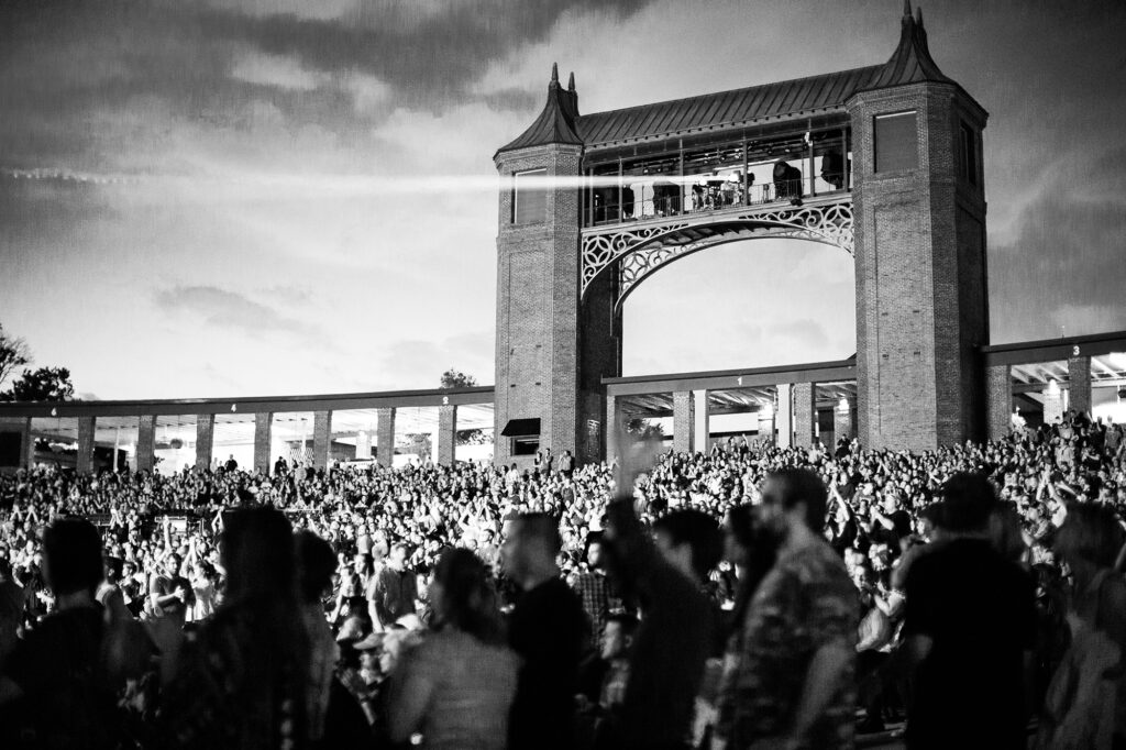 Black and white photo of light bridge and crowd during a concert