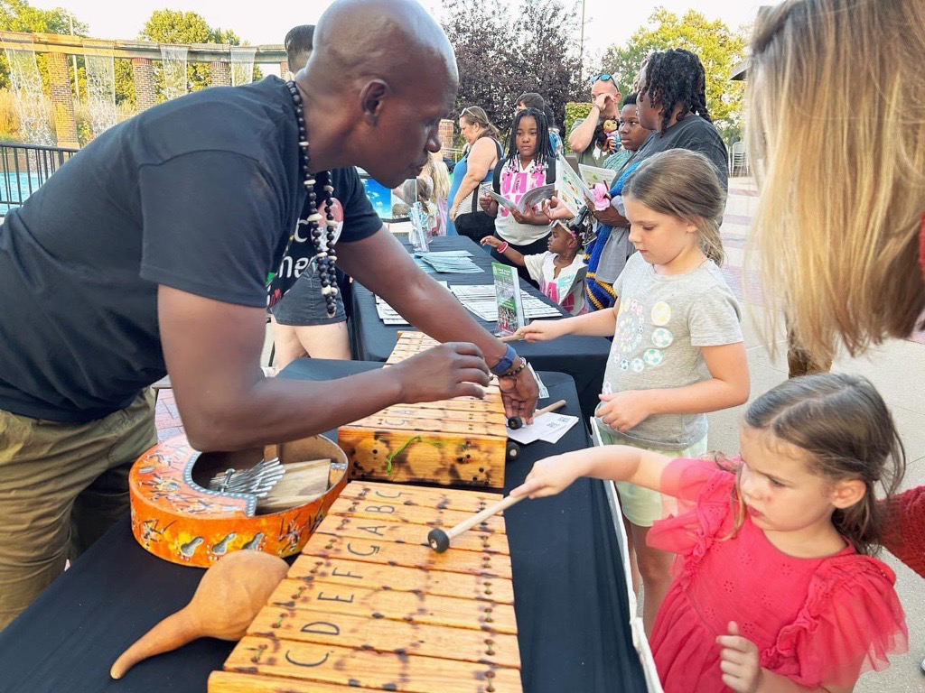 Man showing children how to play an instrument