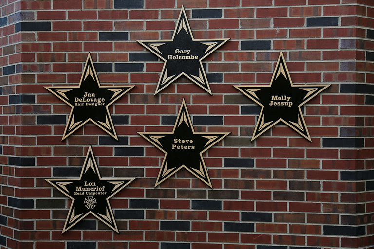 Brick wall with star shaped plaques on it