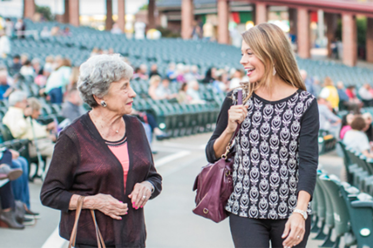 Older and younger woman smiling as they walk through Starlight seating