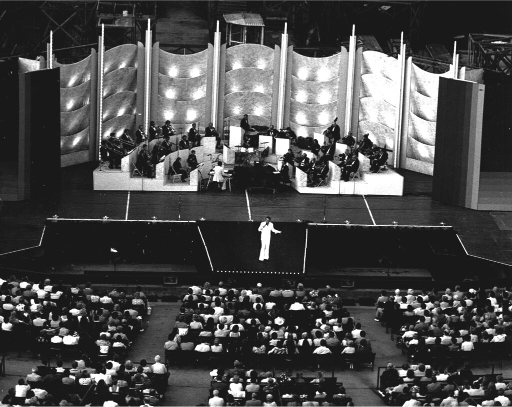 Black and white photo of audience and stage during Peter Marshall performance in 1975