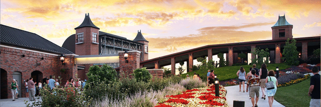 People walking past bright flowers into Starlight during the evening with a sunset